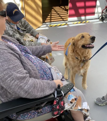 A resident enjoying a relaxed moment with a visiting therapy dog