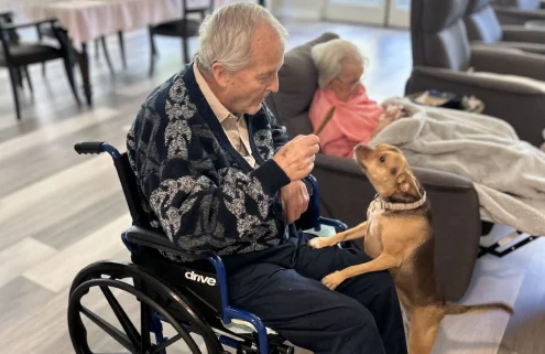 Resident spending time with a small companion dog