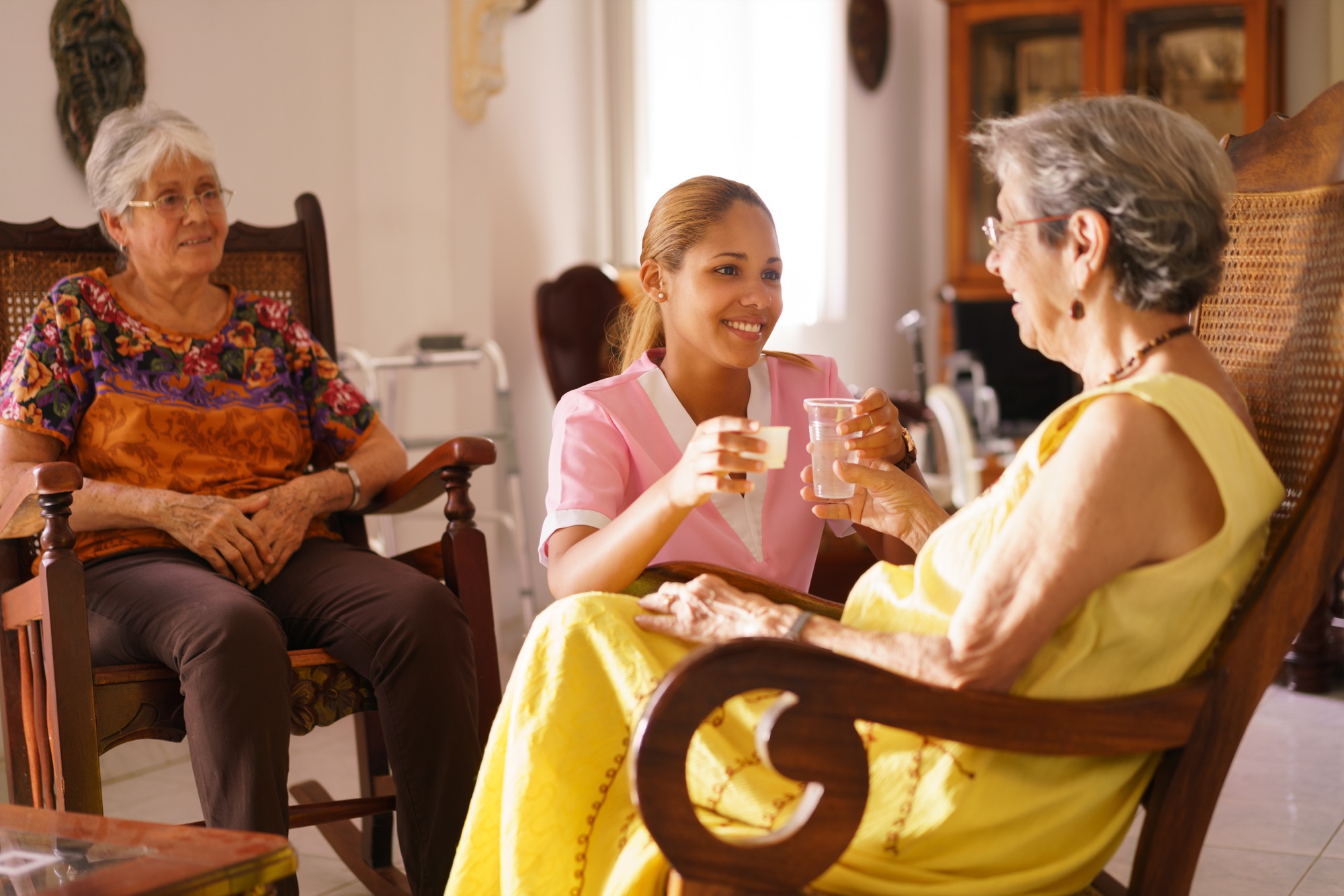 Caregiver offering residents refreshments in a home-like setting